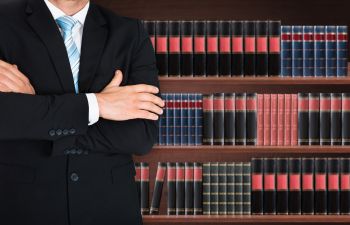 Lawyer Posing in Front of Shelf of Law Books