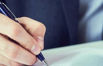 Hand of businessman in suit filling and signing with blue pen