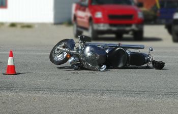 Motorcycle lying on the road after being hit by a car.