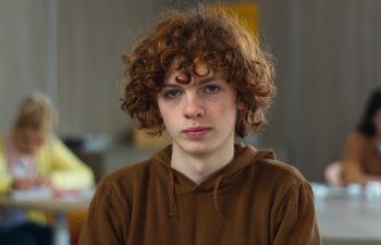 High school university teenager education study calm smiling peaceful serious Caucasian guy boy pupil teen male man schoolboy student studying learning college looking at camera class lesson portrait